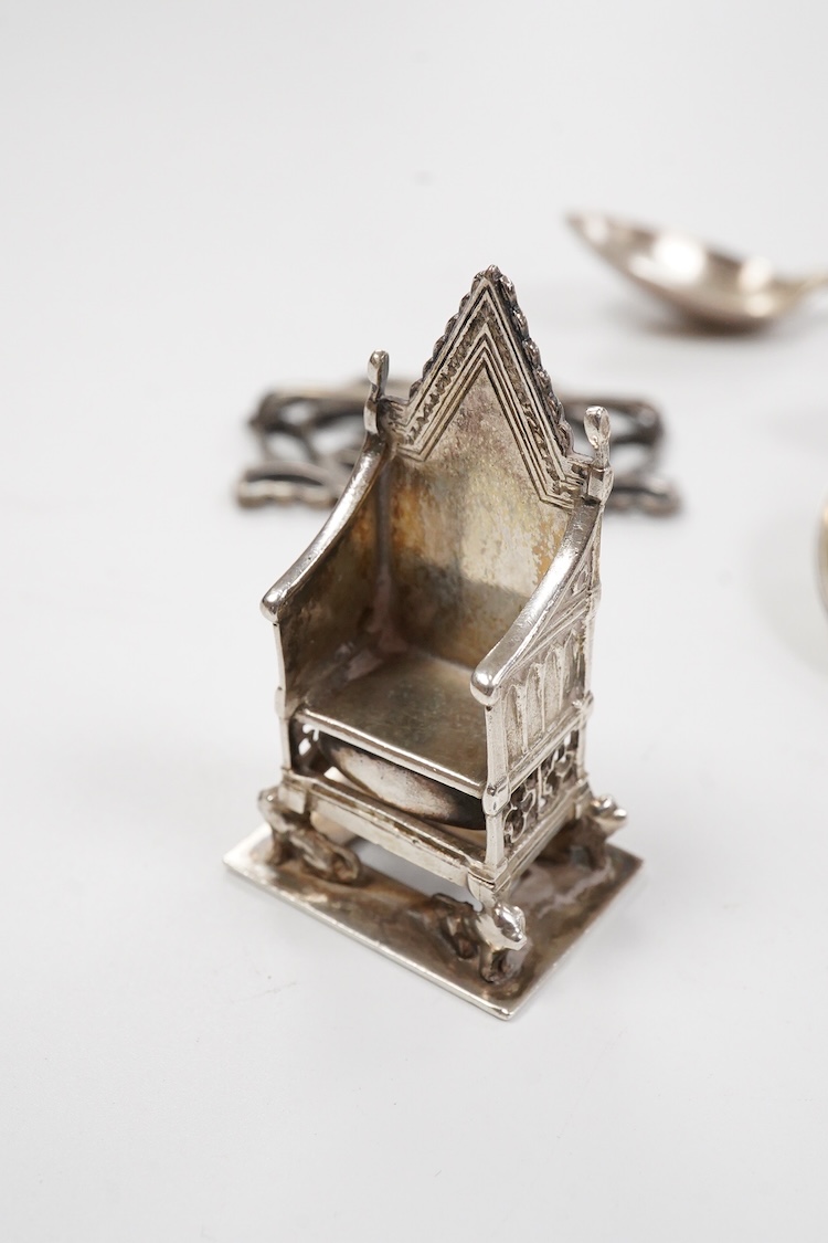 A small group of silver including an Edwardian miniature model of a throne by Edward Foligne Braham, Birmingham, 1901, 50mm, a small comport, one part of a belt buckle and three commemorative spoons, together with a gilt